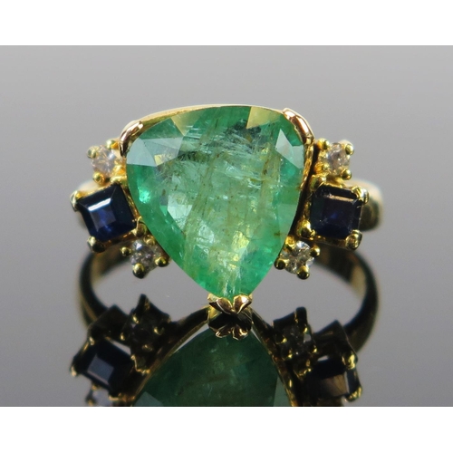 64 - A 14K Gold, Emerald, Sapphire and Diamond Dress Ring, the c. 11.5x10mm central stone in a claw setti... 