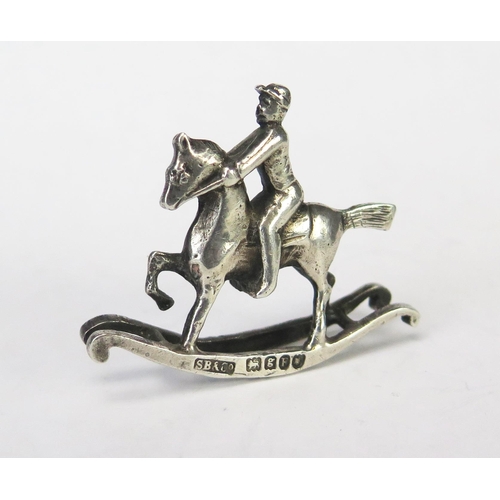 644 - A Continental silver novelty miniature rocking horse and rider, bears import marks for Singleton Ben... 