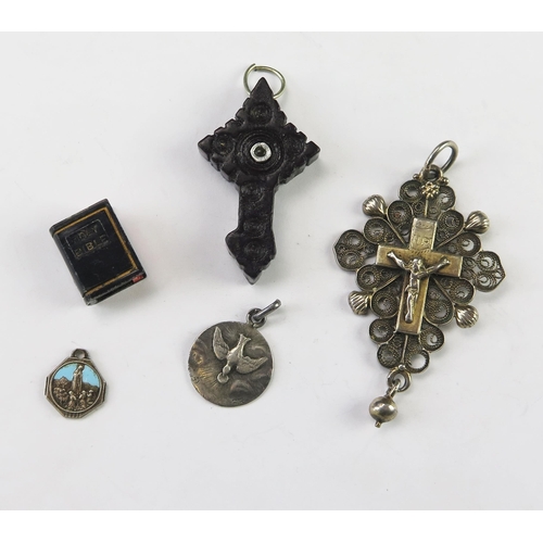 658 - A silver filigree crucifix, silver pendants, wood cross incorporating a stanhope, a model bible with... 