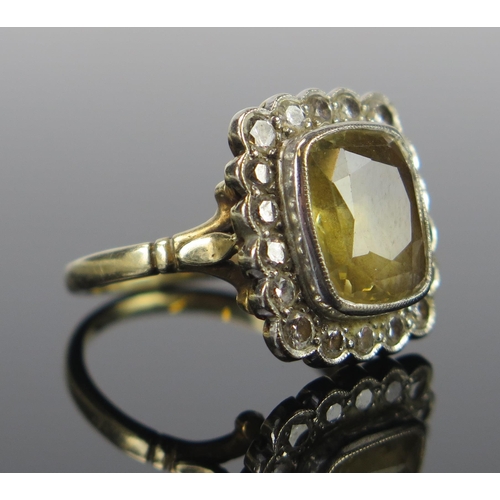 82 - An 18ct Gold,  Yellow and Diamond Cluster Ring, the c. 12x11mm stone in a millegrain setting, London... 