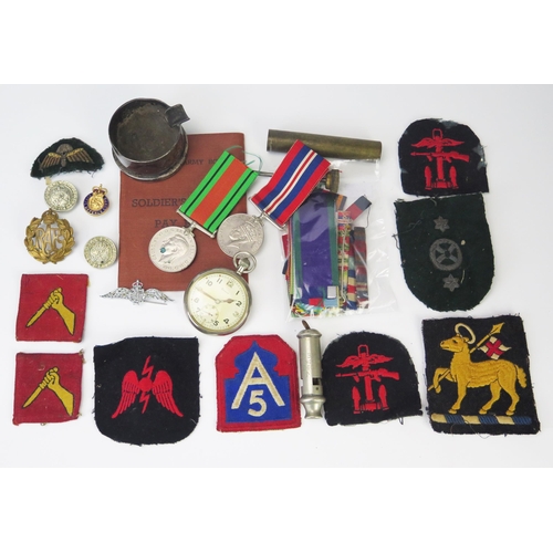 957 - A collection of WWII period militaria including War and Defence Medals, cloth badges, pay book, mili... 