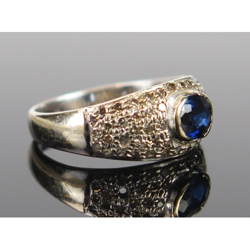 97 - An 18ct White Gold, Sapphire? and Diamond Ring, the central c. 6x5mm stone in a rub over setting, si... 