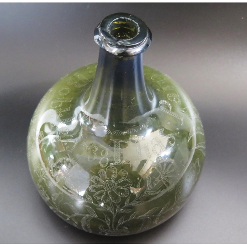 1287 - An early 18th century green glass wine bottle of onion shaped outline with scratched decoration of f... 