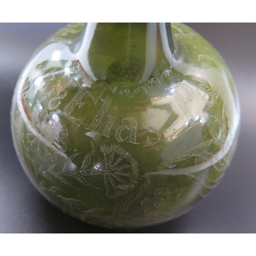 1287 - An early 18th century green glass wine bottle of onion shaped outline with scratched decoration of f... 