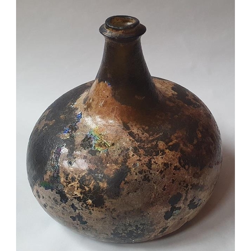 1298 - An 18th century green glass onion-shaped wine bottle, 14cm high. (reputedly unearthed in Devon).