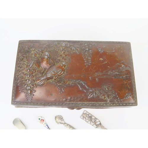 681 - A Japanese antinomy box containing a Chinese silver caddy spoon, and other plated spoons.