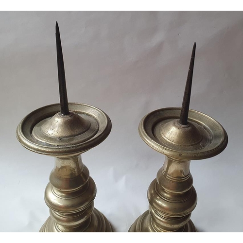 918A - A pair a 19th century pricket candlesticks, with knopped stems and domed circular bases, 36cm high