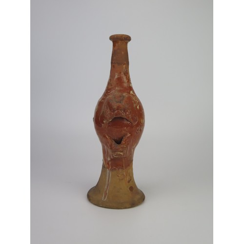 1259 - A late 17th century continental slipware bottle with masque decoration, possibly Italian, 28cm high,