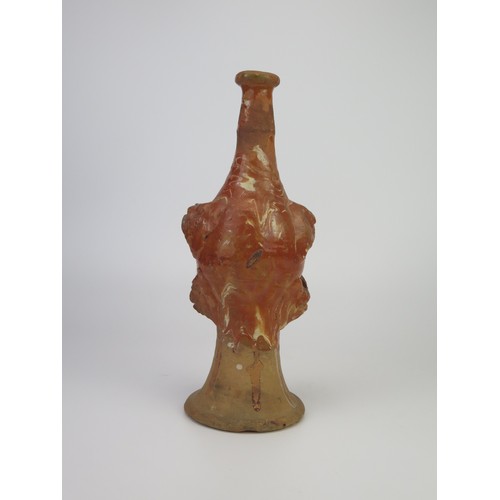 1259 - A late 17th century continental slipware bottle with masque decoration, possibly Italian, 28cm high,