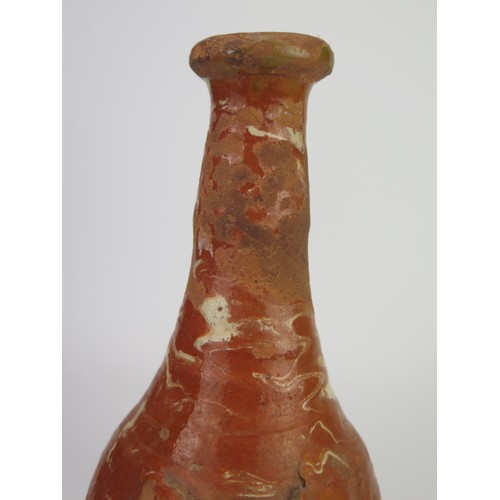 1259 - A late 17th century continental slipware bottle with masque decoration, possibly Italian, 28cm high,