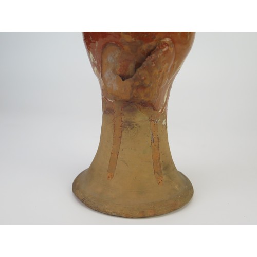 1259 - A late 17th century continental slipware bottle with masque decoration, possibly Italian, 28cm high,