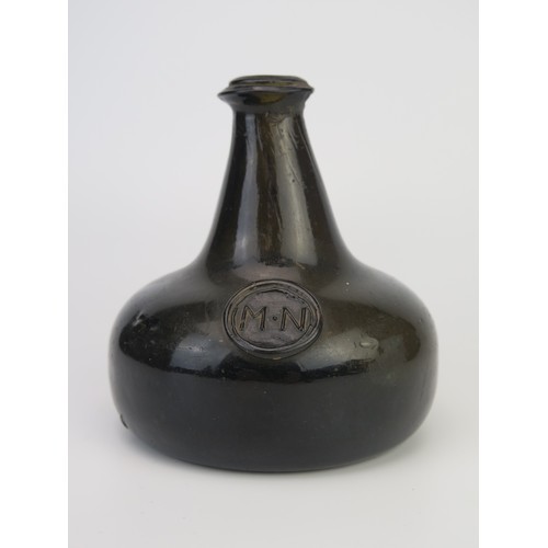 1299 - An 18th century green glass onion-shaped wine bottle, bears seal 'MN', 13cm tall,