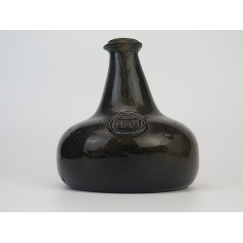 1299 - An 18th century green glass onion-shaped wine bottle, bears seal 'MN', 13cm tall,