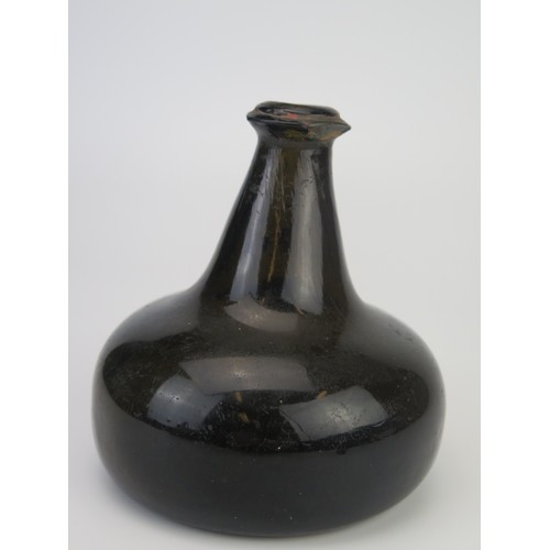 1299 - An 18th century green glass onion-shaped wine bottle, bears seal 'MN', 13cm tall,