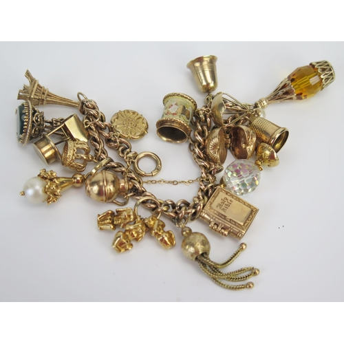 12 - A 9ct Gold Charm Bracelet set with sixteen charms including the Eiffel Tower, the Three Wise Monkeys... 