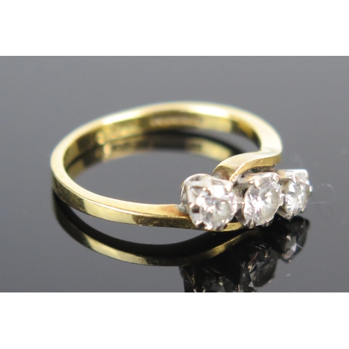 128 - An 18ct Gold and Diamond Three Stone Crossover Ring, largest c. 4.1mm, size K, 3.4g. Shank slightly ... 