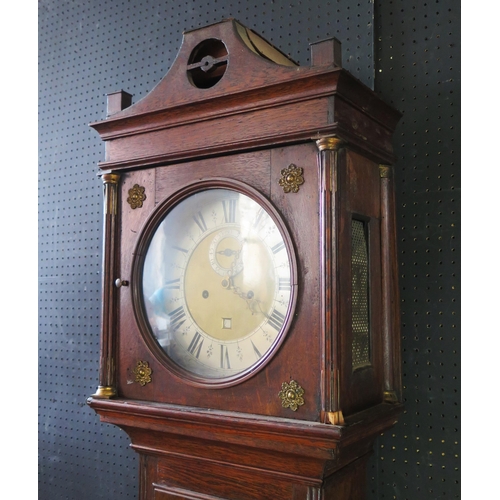 1314 - An early 19th century oak longcase clock, the arched hood with fluted columns, the trunk having a  p... 