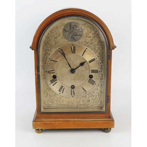 1316 - A mahogany mantel clock of arched outline with silvered arched Roman dial, the HALLER triple train m... 