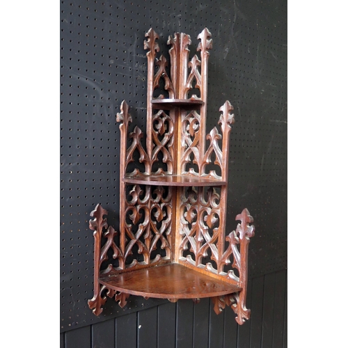 1333 - A Gothic revival mahogany corner shelf,  with pierced spire and fleur d'lys decorated back having th... 