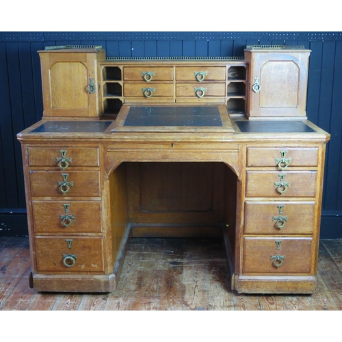 1342 - A late Victorian/Edwardian oak twin pedestal writing desk, the superstructure with sunken centre sec... 