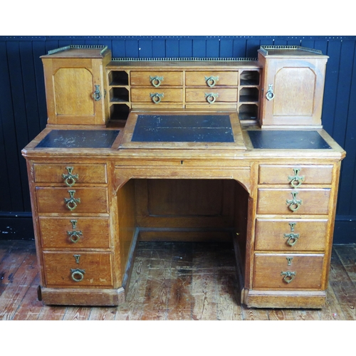 1342 - A late Victorian/Edwardian oak twin pedestal writing desk, the superstructure with sunken centre sec... 