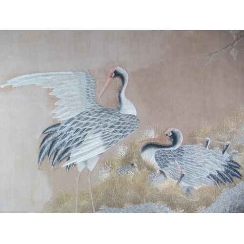 1384 - A large Japanese silk picture of a pair of cranes and their young, worked in coloured silks, F & G 7... 