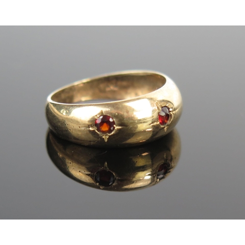 163 - A 9ct Gold and Garnet Three Stone Gypsy Ring, size M.75, 2.3g