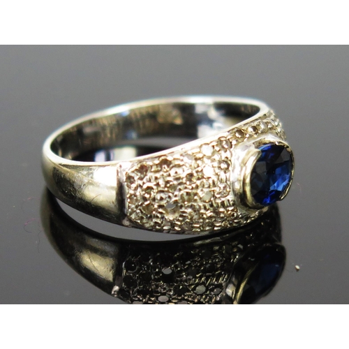 208 - An 18ct White Gold, Sapphire and Diamond Ring, the central c. 6x5mm stone in a rub over setting, siz... 