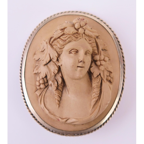 231E - A Victorian Carved Lava Cameo Brooch decorated with a female bust and in a white metal setting, 51x4... 