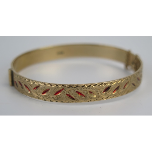 69 - A 9ct Gold Hinged Bangle with chased foliate decoration with red enamel highlights, full Birmingham ... 