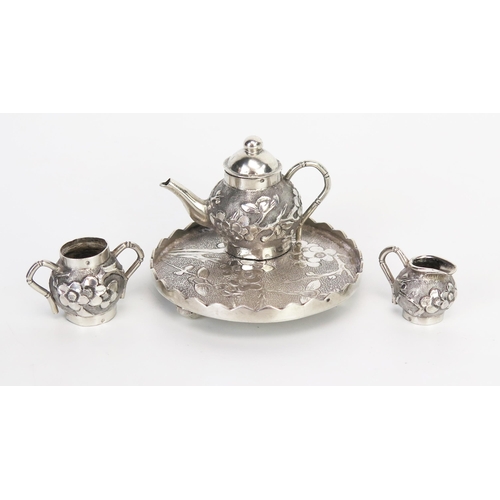 757 - A Chinese silver miniature tea service and tray, with prunus decoration, total weight of silver 49gm... 