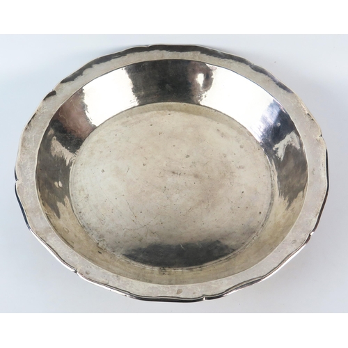 779B - A large white metal bowl, of plain circular form, unmarked but initialled, having a wavy edge border... 