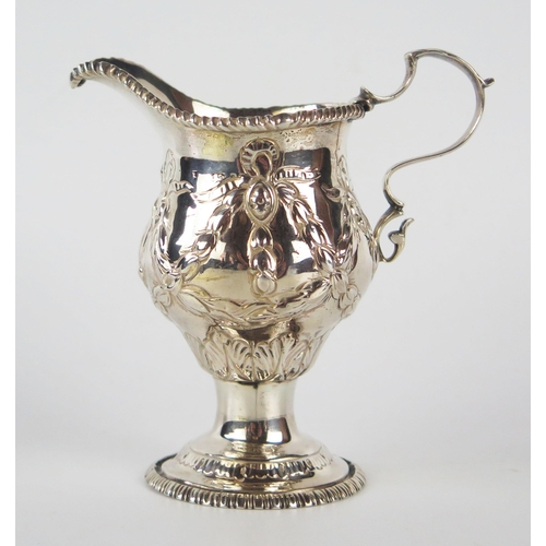 797 - A silver pedestal cream jug, marks worn and over decorated, with beaded border, with swag and garlan... 