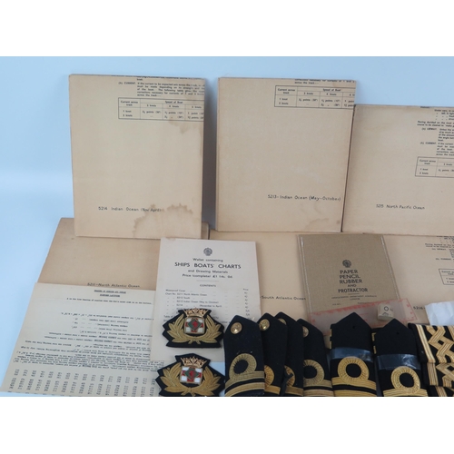 911 - A collection of naval officers epaulettes, cap badges, buttons, together with naval charts for the N... 