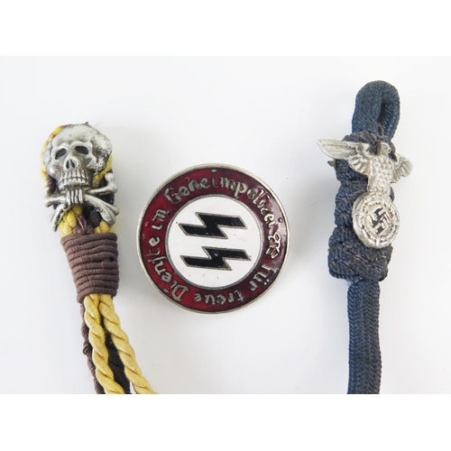 939 - A replica SS police enamel badge, and two woven part hangers with totenkopf badge and another with n... 