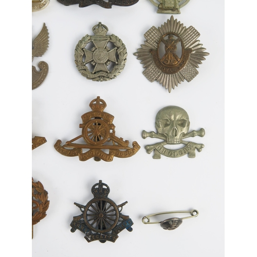 946 - A collection of British regimental cap badges, includes Royal Scots Guards, Royal Artillery, Devonsh... 