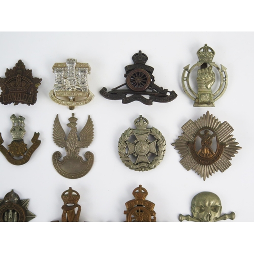 946 - A collection of British regimental cap badges, includes Royal Scots Guards, Royal Artillery, Devonsh... 