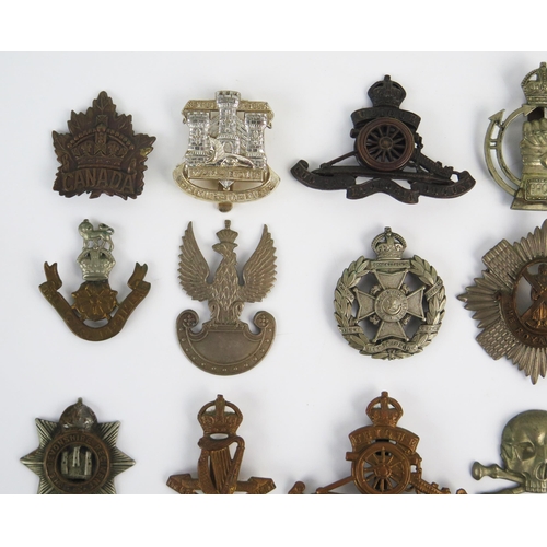 946 - A collection of British regimental cap badges, includes Royal Scots Guards, Royal Artillery, Devonsh... 