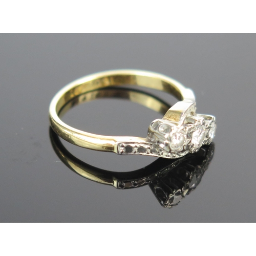 95 - A Diamond Three Stone Crossover Ring in an 18ct gold and platinum setting, central stone c. 3mm, siz... 