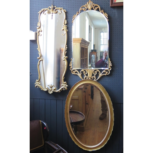 1347 - An oval gilt framed mirrors together with two other foliate and scroll decorated gilt framed mirrors... 