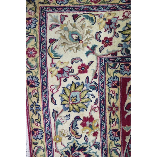 1348 - A Tabriz rug, the central wine red field with all over trailing foliage and flowerheads, enclosed by... 