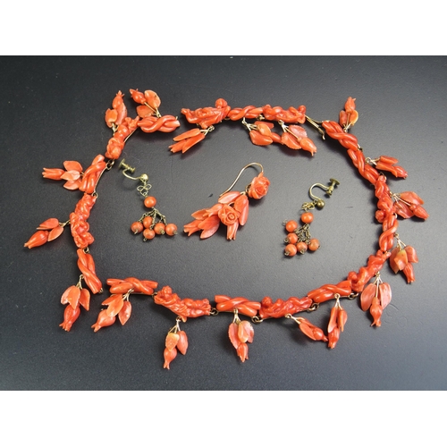 13 - An Antique Carved Coral Necklace decorated with putti, knot and foliate drops, a single pendant earr... 