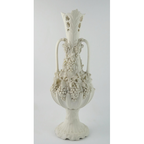 1358 - A Parian Bacchanalian vase of slender ovoid form with pierced neck and decorated all over with vine ... 