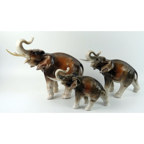 1412 - A set of three Royal Dux porcelain graduated elephants, 38cm, 28cm and 23cm long. 3).