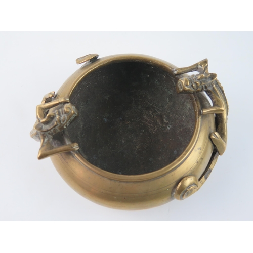 1415 - A Chinese bronze censer of squat circular form decorated with two dragons, holding the rim, bears ps... 