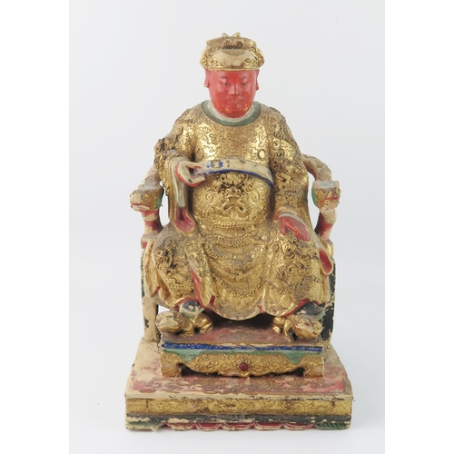 1420 - A late 19th century polychrome carved wooden figure of a seated emperor, with gilded decoration, 30c... 