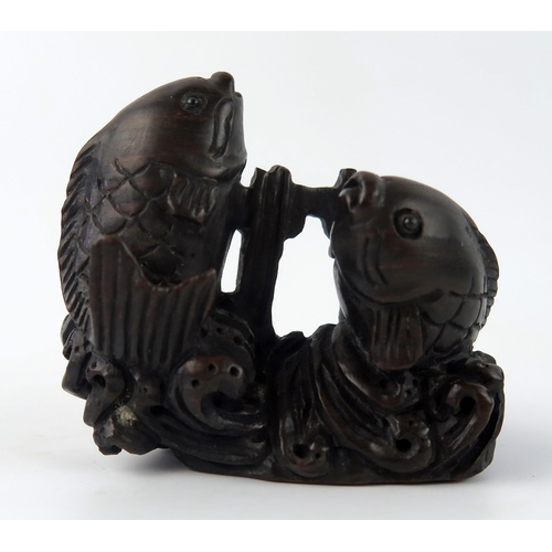 1432 - A Japanese carved and stained hardwood netsuke in the form of two leaping carp, unsigned, 5cm wide.