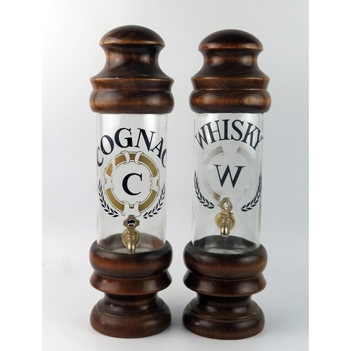 1562 - Two continental turned wood and glass spirit dispensers, 'Cognac' and 'Whisky', each with metal tap,... 