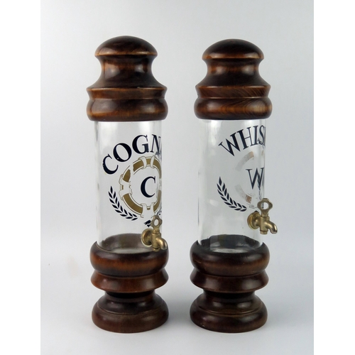 1562 - Two continental turned wood and glass spirit dispensers, 'Cognac' and 'Whisky', each with metal tap,... 