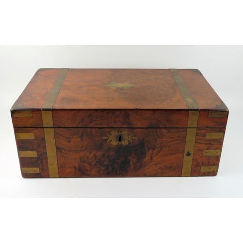 1570 - A Victorian walnut and brass bound campaign writing slope, the hinged lid enclosing a tooled leather... 